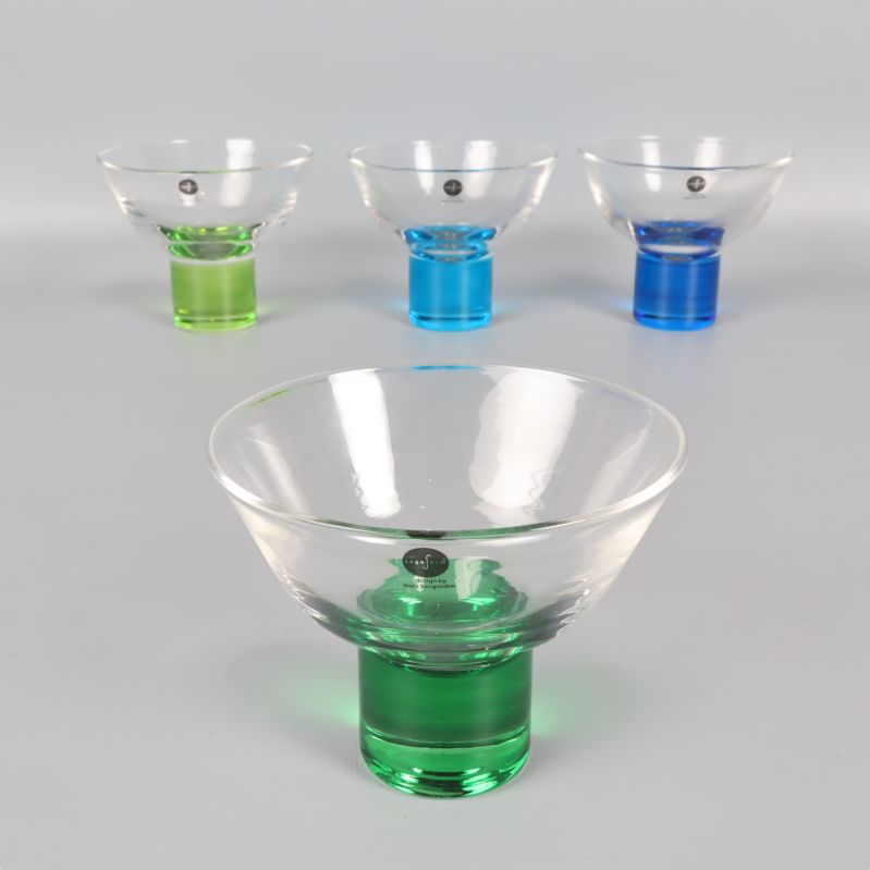 Fyra martiniglas med olika färg på foten