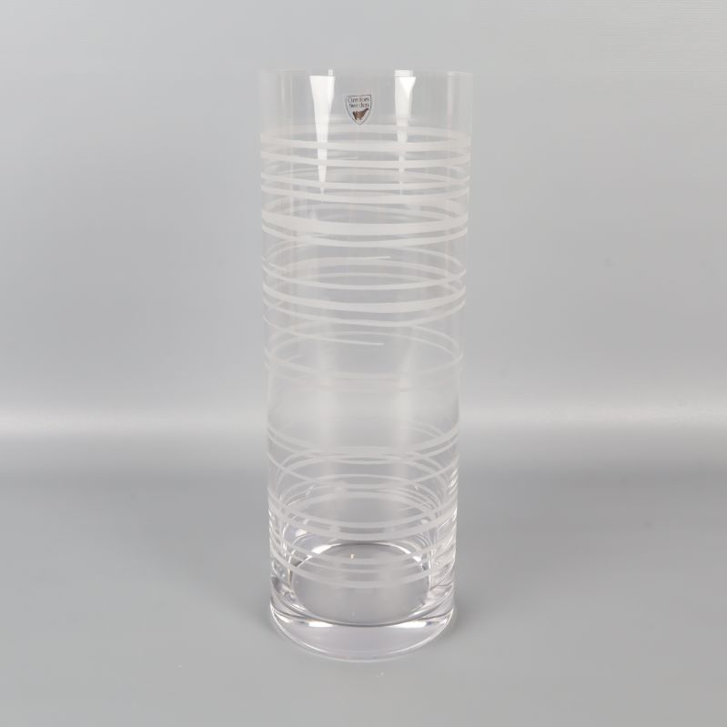 Genomskinlig glasvas i helfigur med mönstrade linjer