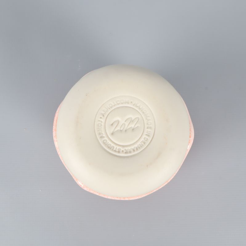 Undersidan av keramikmugg med stämpel och vit botten