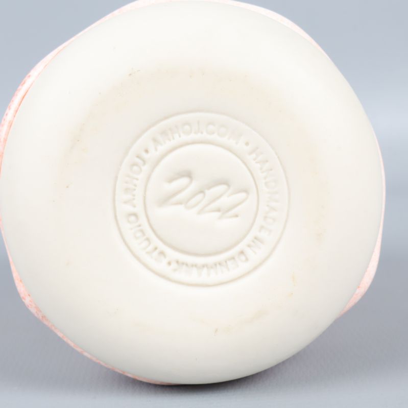 Undersidan av mugg med präglad text