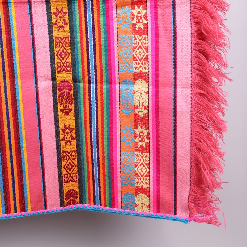 Hörn av textil med fransar och färgglada mönster