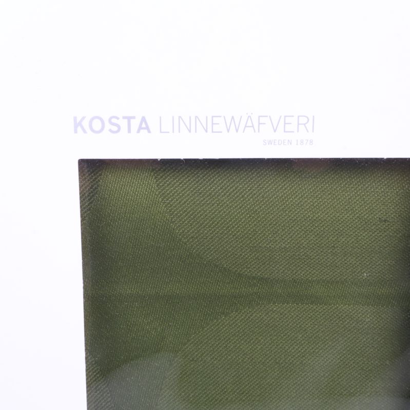 Närbild på Kosta Linnewäfveri-loggan på vit kartong