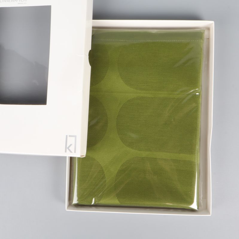 Grön löpare syns i plastskydd i öppen förpackning