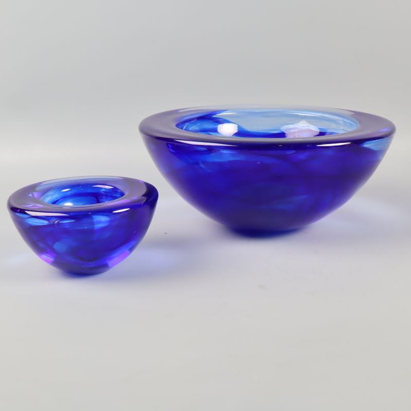 Sida av två blå glasskålar i genomskinligt glas