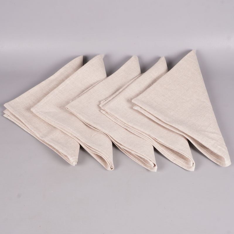 Fem vikta beige tygservetter i rad