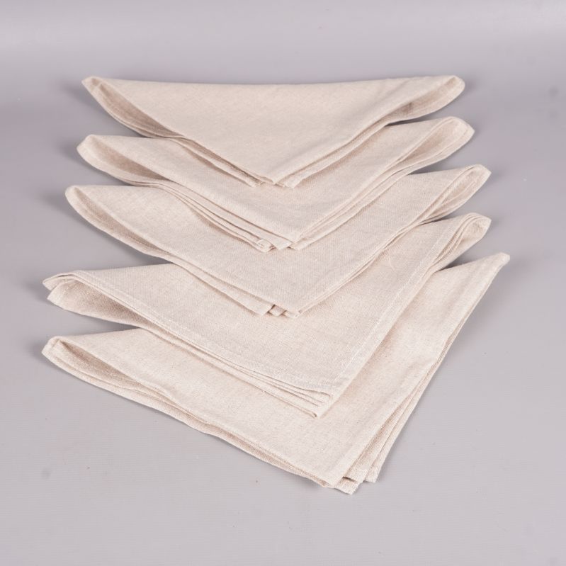 Flera staplade tygservetter i ljus beige nyans