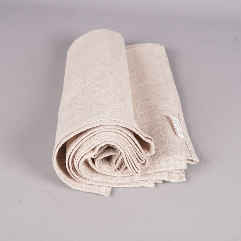 Rullade beige tygservetter placerade bredvid varandra