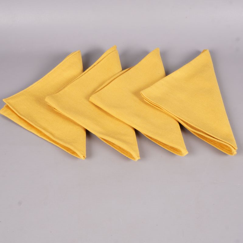 Fyra vikta gula tygservetter i en rad