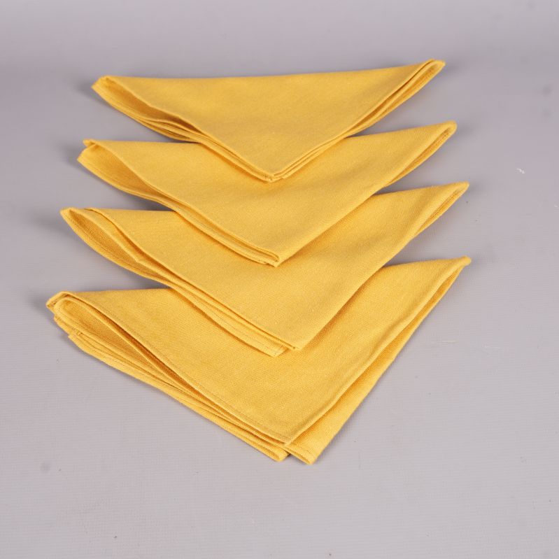 Fyra gula tygservetter lagda ovanpå varandra