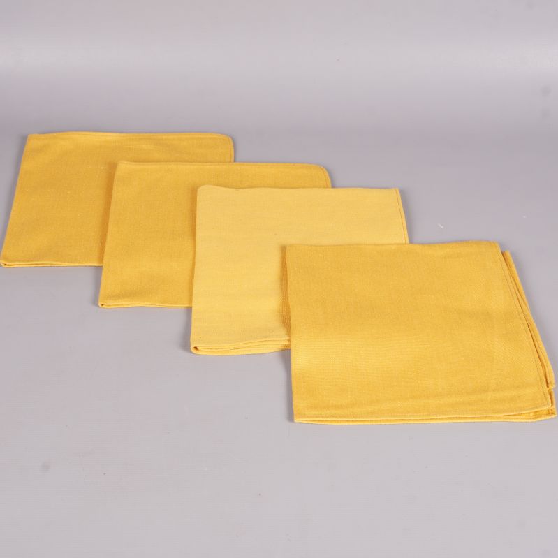 Gula tygservetter utlagda platt i en rad