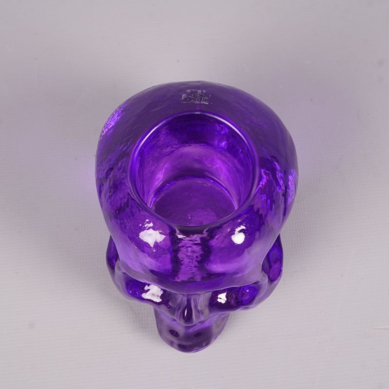 Lila dödskalle ljushållare sedd uppifrån med ljushållarens öppning