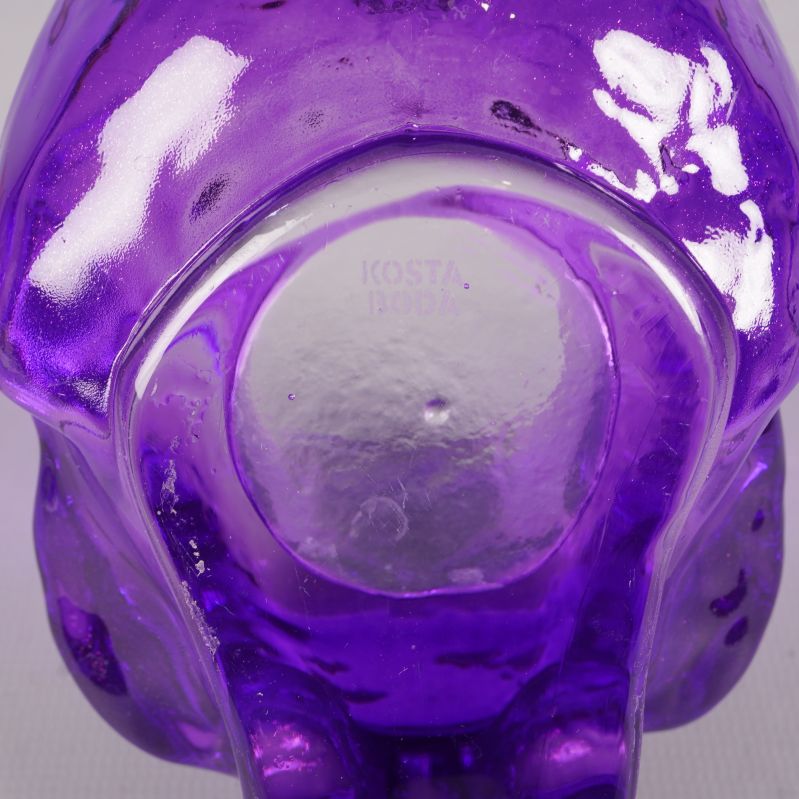 Närbild av undersidan på lila dödskalle ljushållare med Kosta Boda text