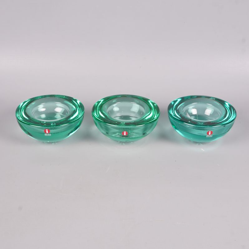 Tre runda gröna glaskandelabrar i rad