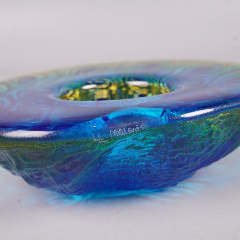 Signering på kanten av blå ljushållare i glas