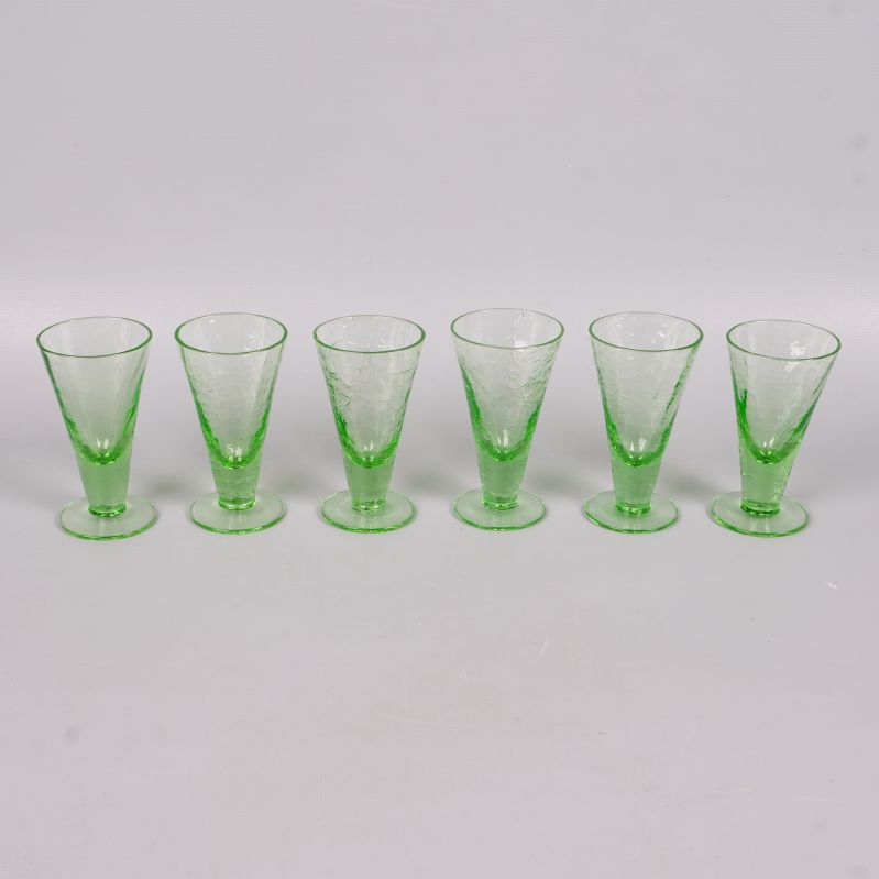 Sex gröna likörglas på rad