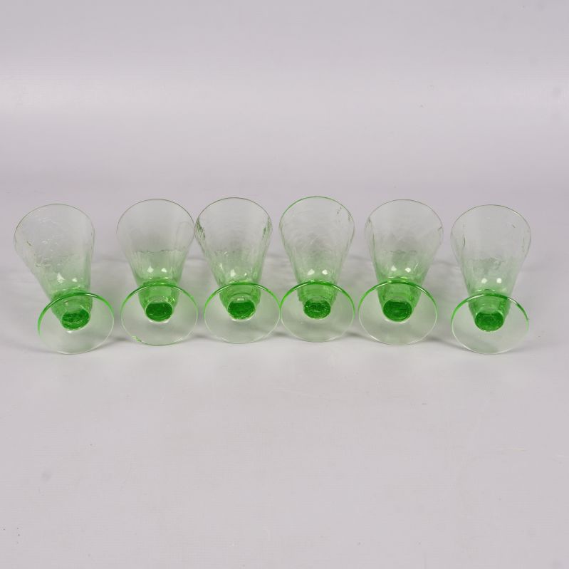 Sex gröna likörglas uppifrån, fokuserar på glaskanter