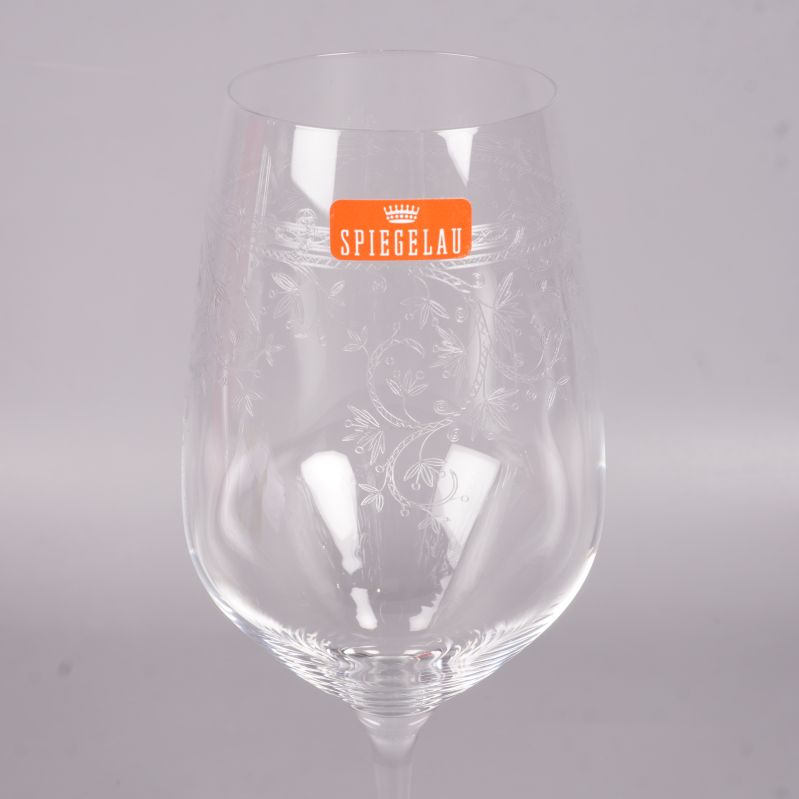 Närbild av ett vinglas med gravyr och Spiegelau-dekal