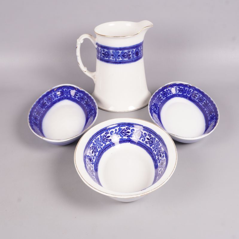 Översiktsbild av kanna och tre skålar med blå bård