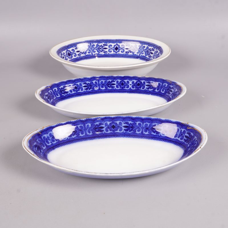 Tre djupa fat med blå kant uppställda i rad