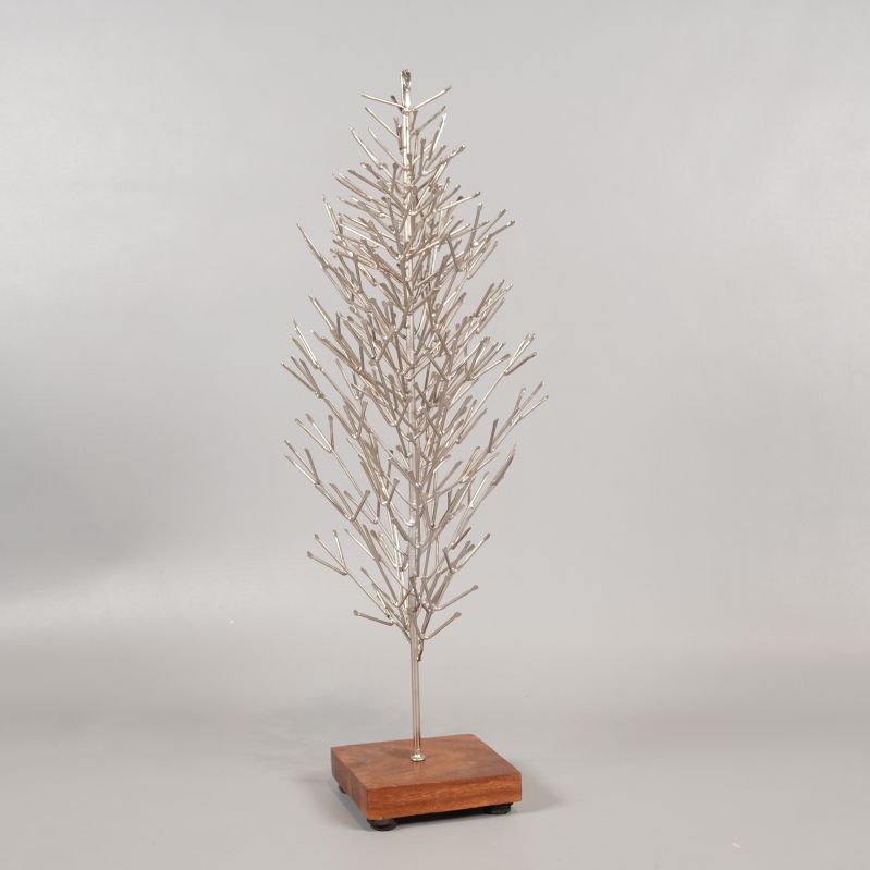 Julgran i metall med tydlig grenstruktur och träbas