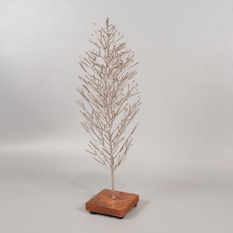 Julgran i metall från sned vinkel på träbas