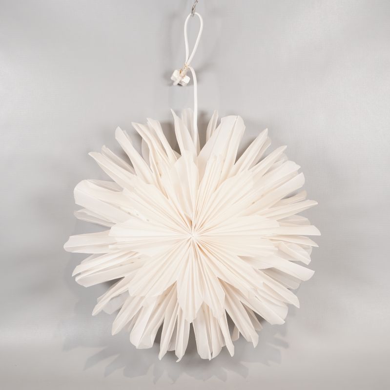 Stor veckad pappersstjärna upphängd med band mot ljus bakgrund