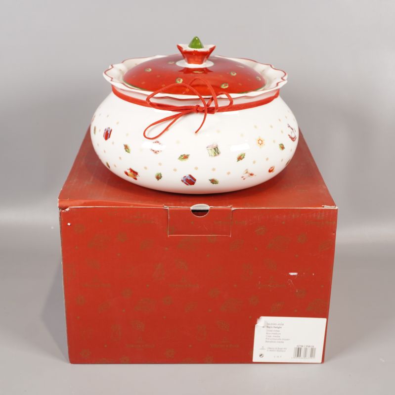 Vit och röd burk med lock ovanpå röd kartong