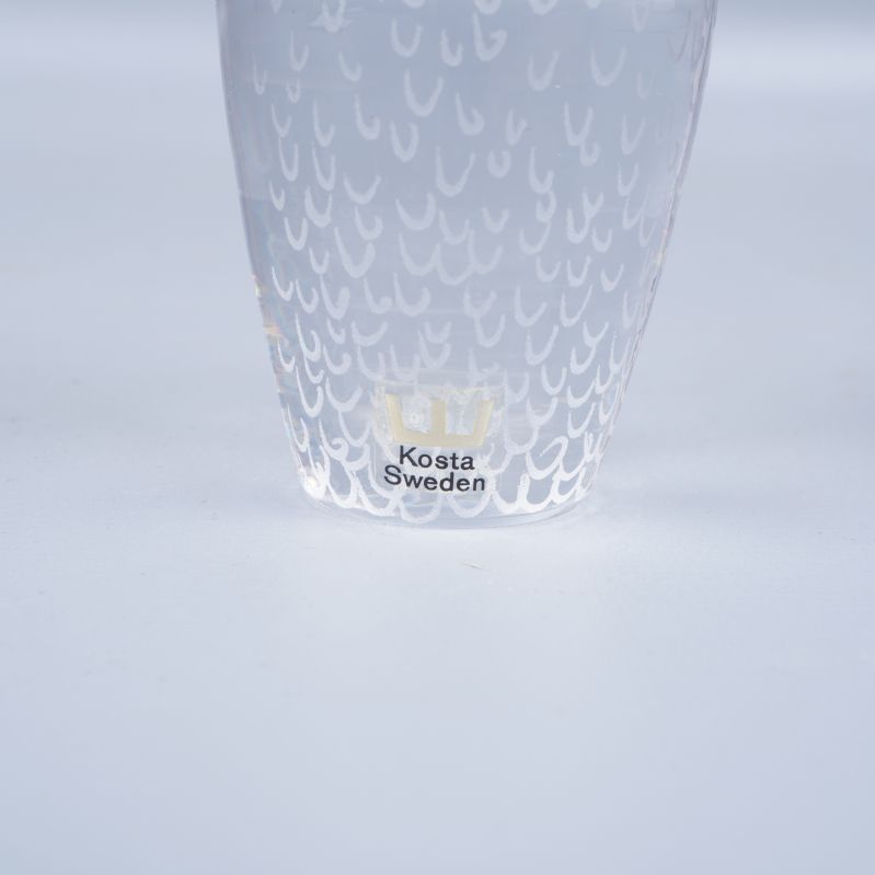 Närbild av märkning Kosta Sweden på glasuggla