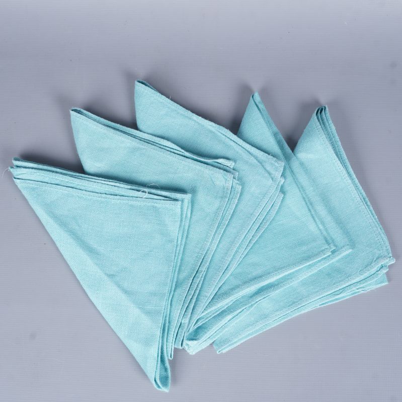 Fem ljusblå tygservetter vikta i lager på grå bakgrund