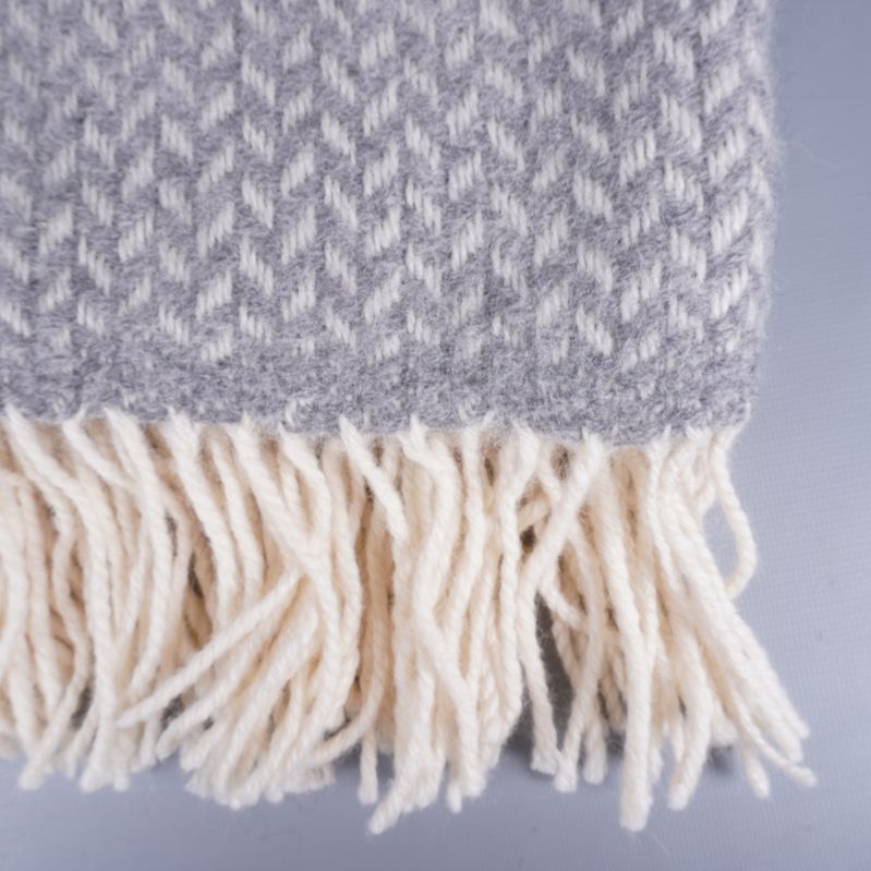 Detaljbild på plädens vita lammullsfransar