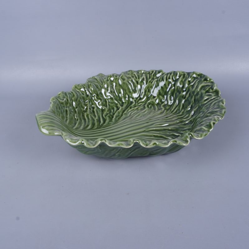 Grön skål i form av ett salladsblad fotograferad snett framifrån