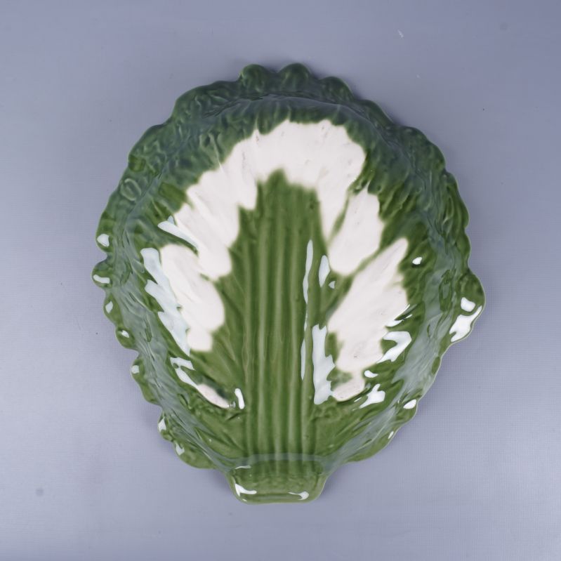 Skålens undersida i grönt och vitt porslin med glansig yta