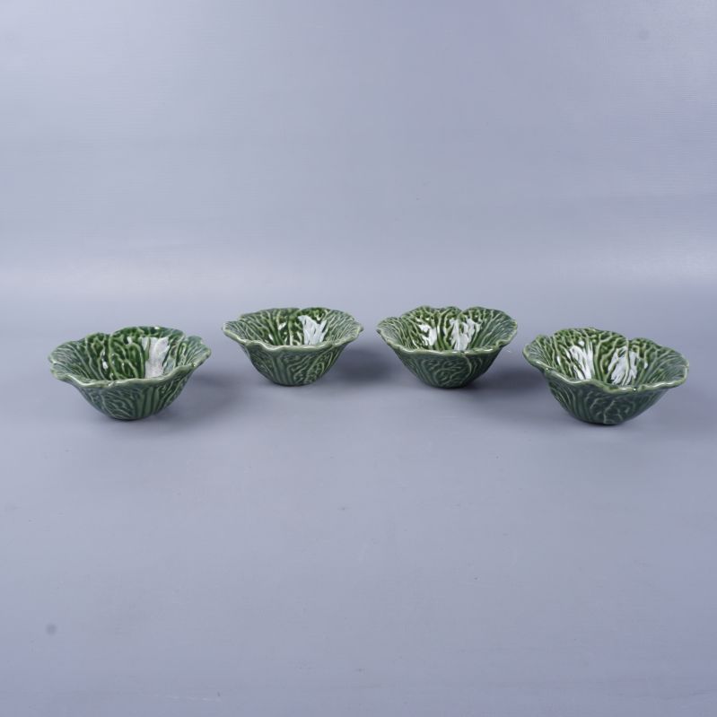 Fyra gröna skålar placerade i rad med bladmönster