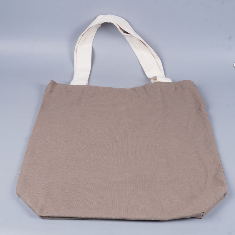 Baksidan av enkel beige tygkasse med ljusa handtag