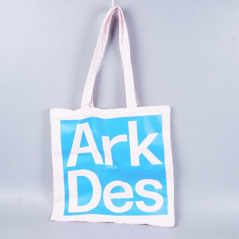 Tygkasse med blått tryck och vita handtag mot grå bakgrund