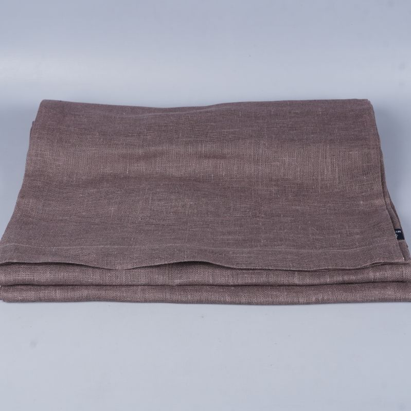 Snyggt vikt brun löpare i vävt tyg mot ljus bakgrund