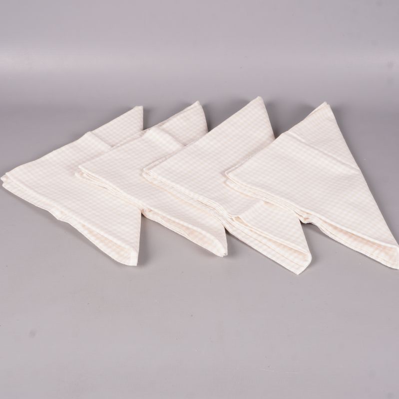 Fyra vikta rutiga tygservetter i ljusa toner