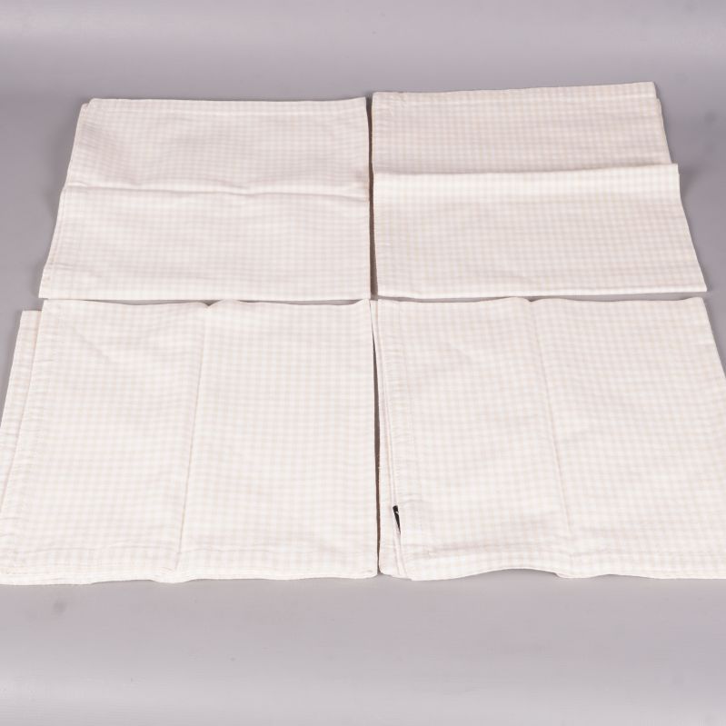 Fyra rutiga tygservetter utlagda plant sida vid sida