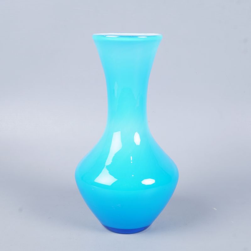 Frontal vy av blå glasvas med smal hals