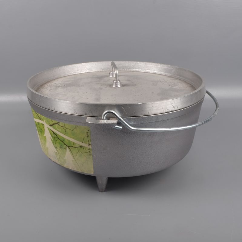 Grytan sedd från sidan med lock och metallhandtag uppfällt