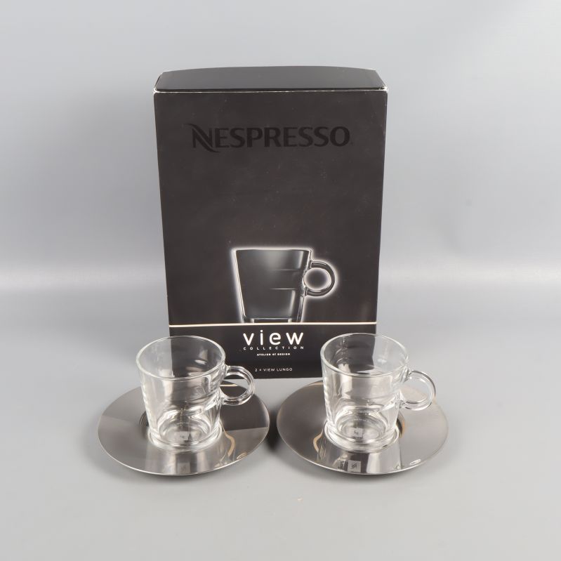 Två glas koppar med metallfat och originalförpackning från Nespresso