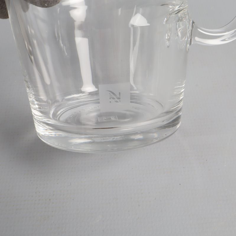 Närbild på Nespresso logo på glasets undersida