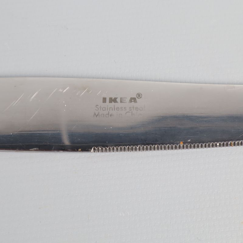 Närbild på kniv med IKEA-logga och texten Stainless steel