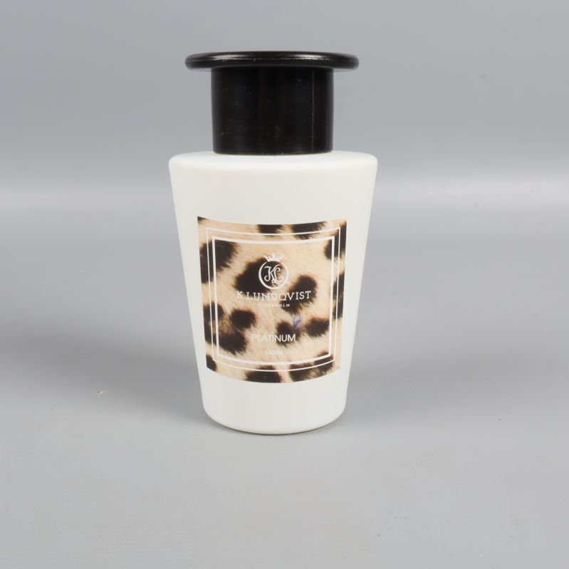 Närbild på doftflaska med svart topp och leopardmönstrad etikett