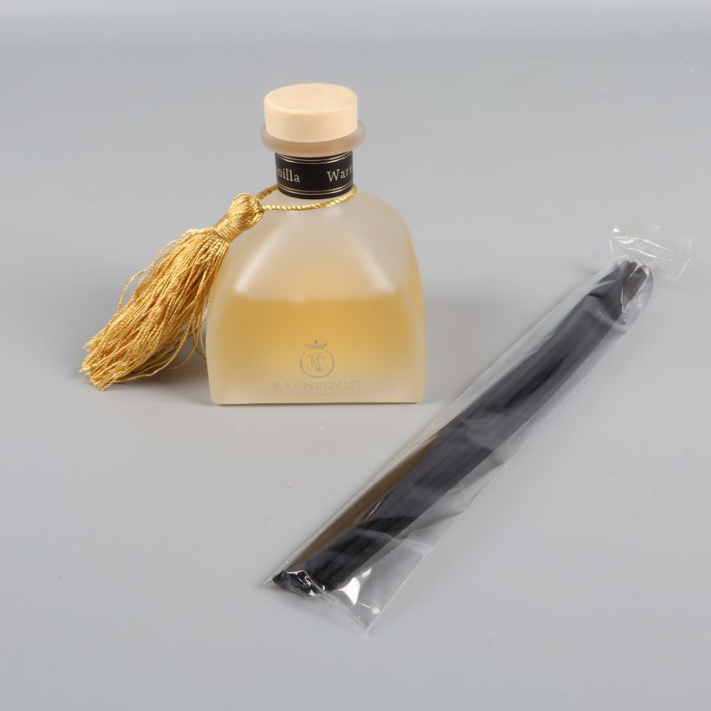 Doftpinnar och frostad flaska med guldig tofs