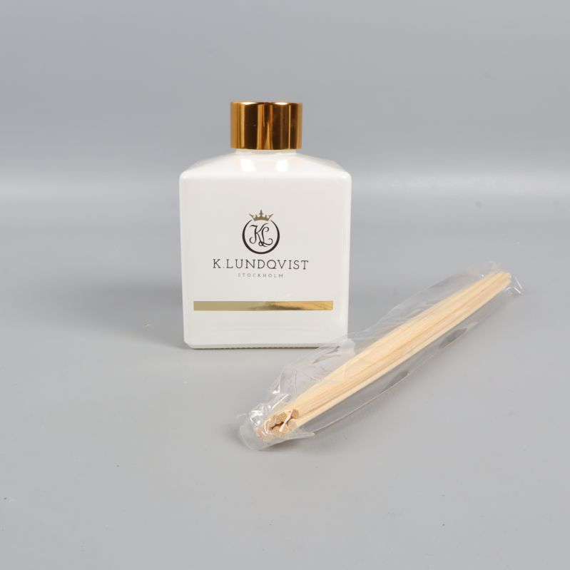 Doftpinnar, vit flaska med guldfärgat lock och stickor