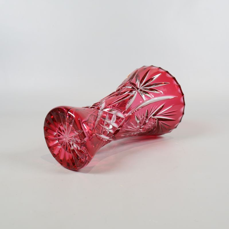 Röd kristallvas placerad liggande på sidan