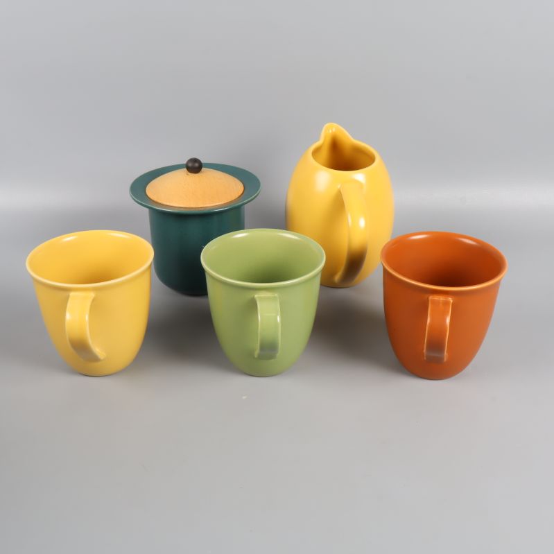 Baksidan av färgglatt muggset med kanna och burk visas upp