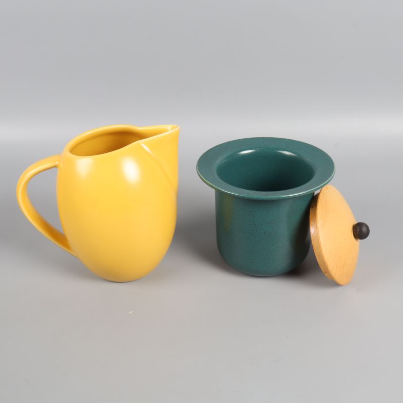 Kanna och burk i gult och grönt separat med lock av trä