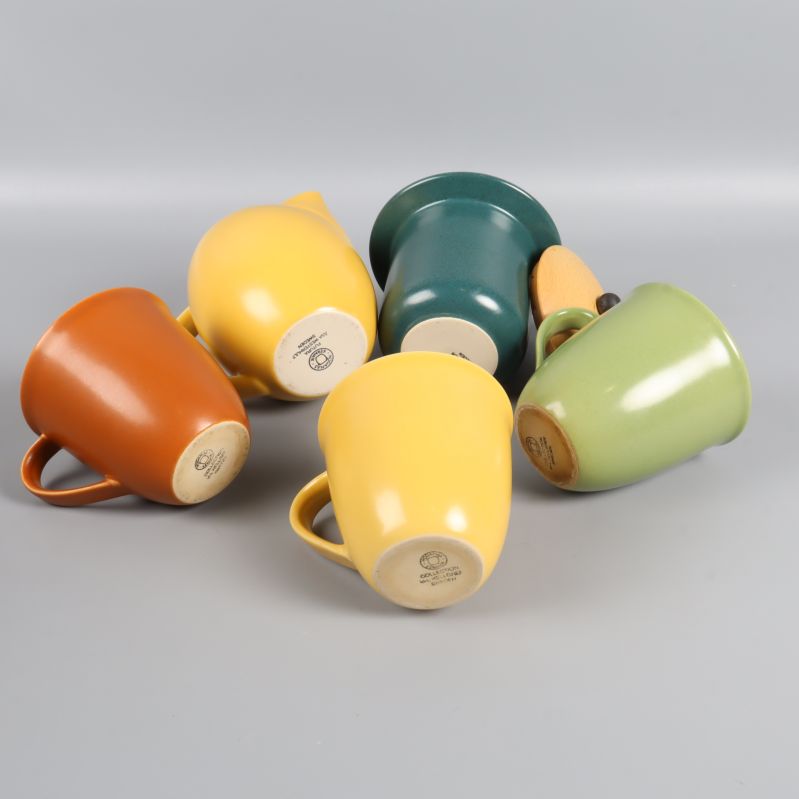 Keramikkannor och muggar liggande med märkning på undersidan synlig